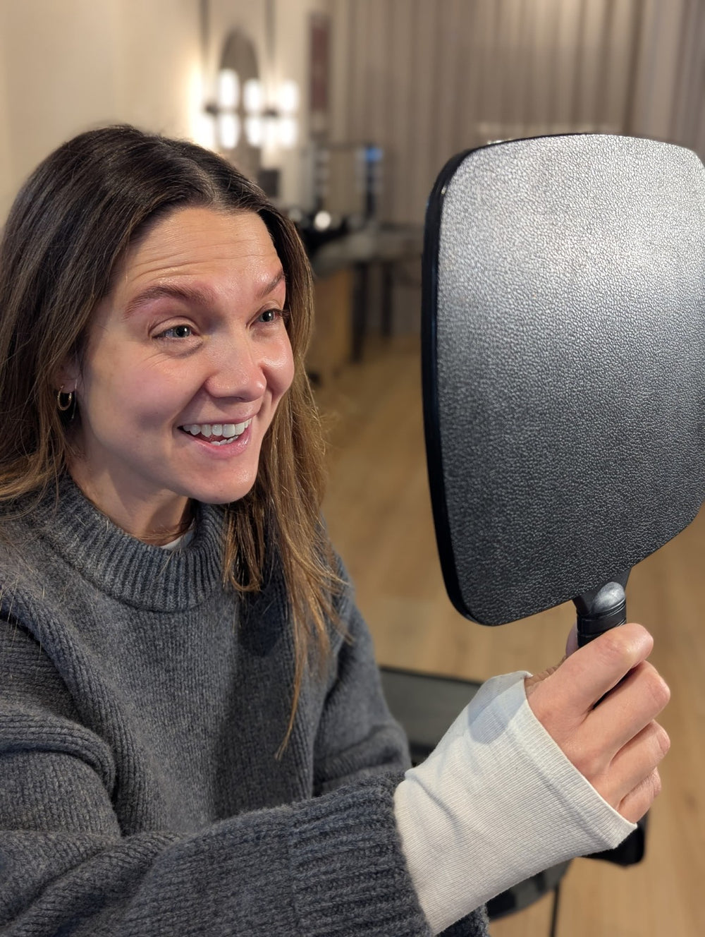 A Microblading client seeing her result in the mirror