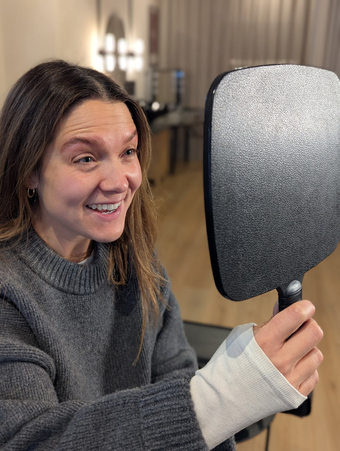 A Microblading client seeing her result in the mirror